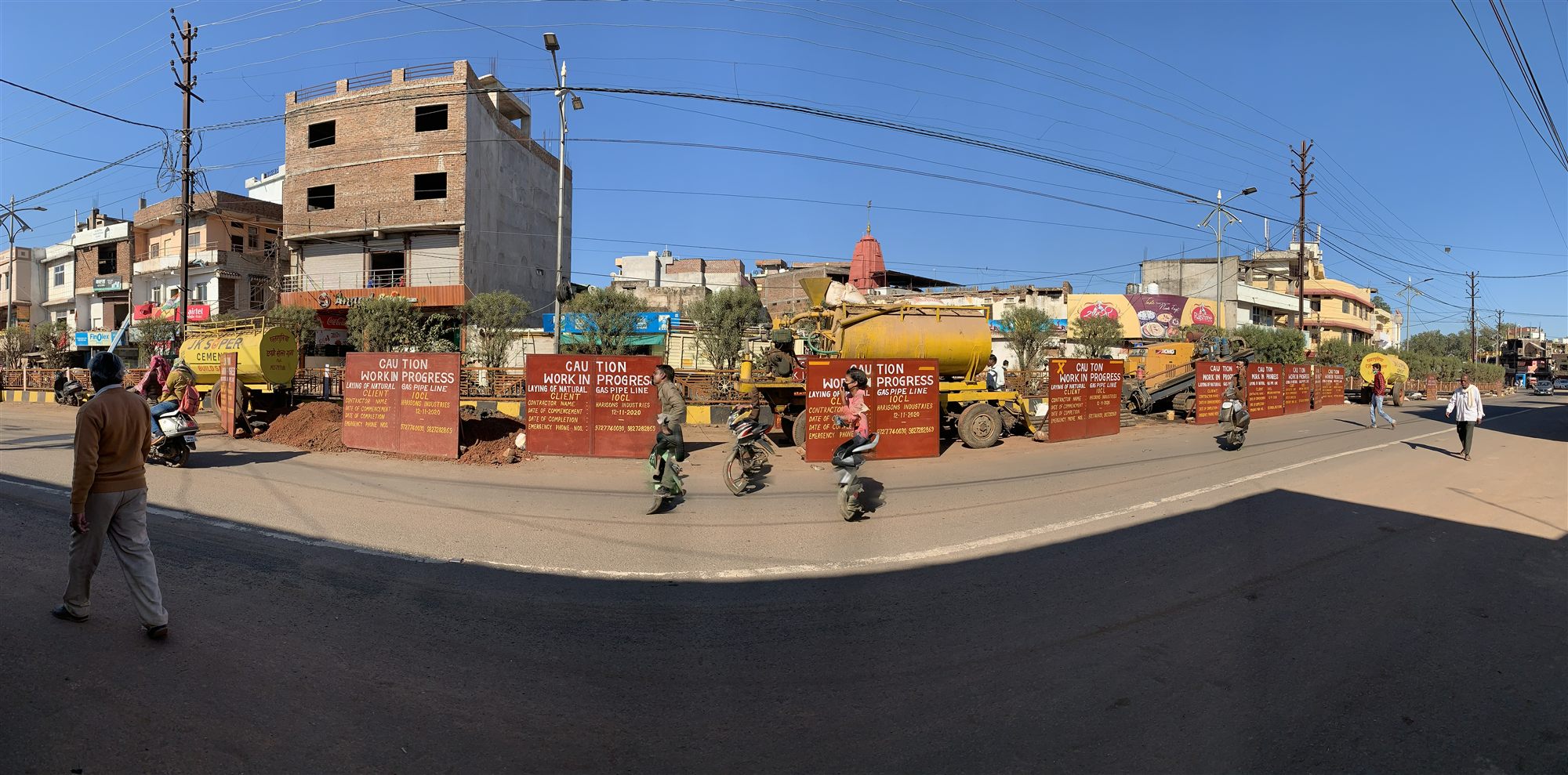Barricaded pipeline construction work front in an urban corridor